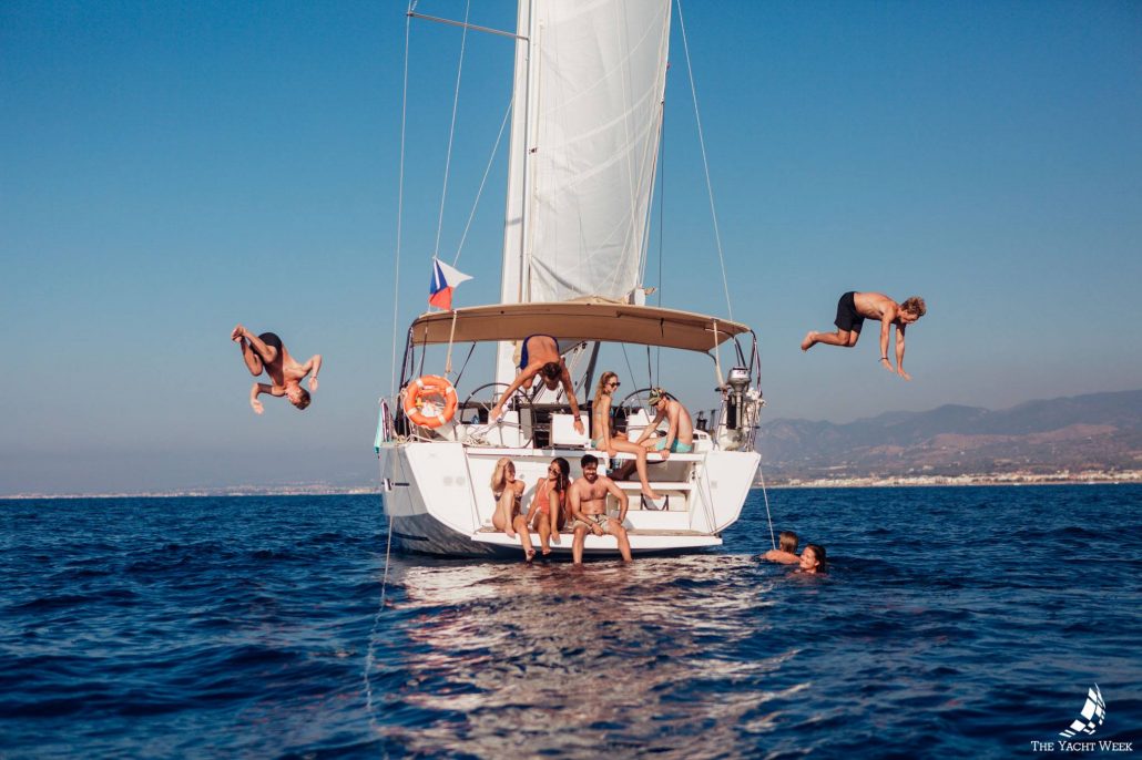 people jumping off sailboat on the yacht week