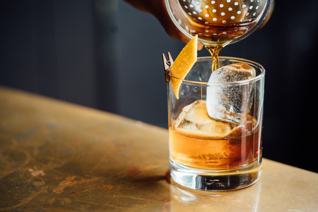 craft cocktail being poured at a bar