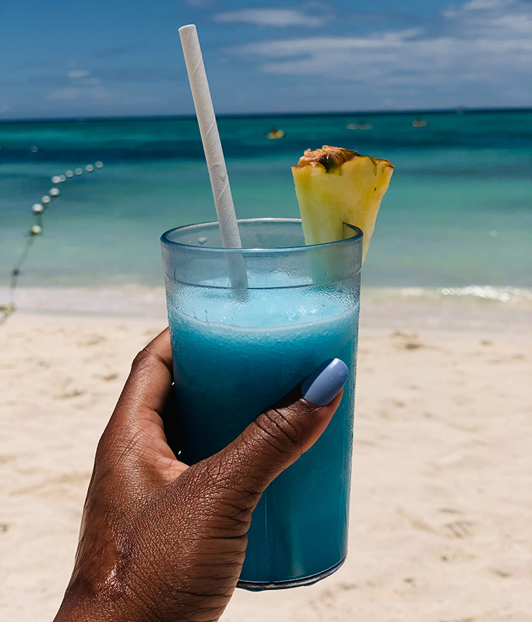 girl drinking cocktail on beach in jamaica